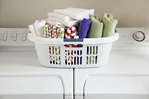 Çamaşır sepeti çamaşır makinesi ve kurutma makinesi üstünde temiz katlanmış havlu