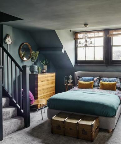 avize ve döşemeli yatak ile koyu mavi gri çatı katı yatak odası