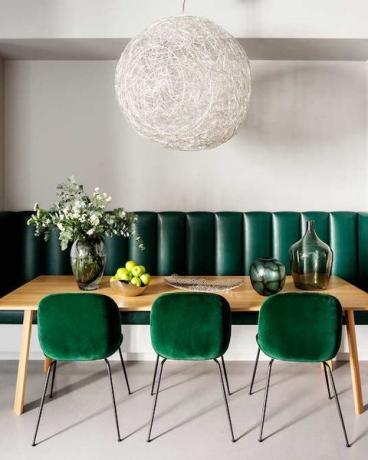 Zümrüt yeşili sandalye ve ışıklı bir yemek odası